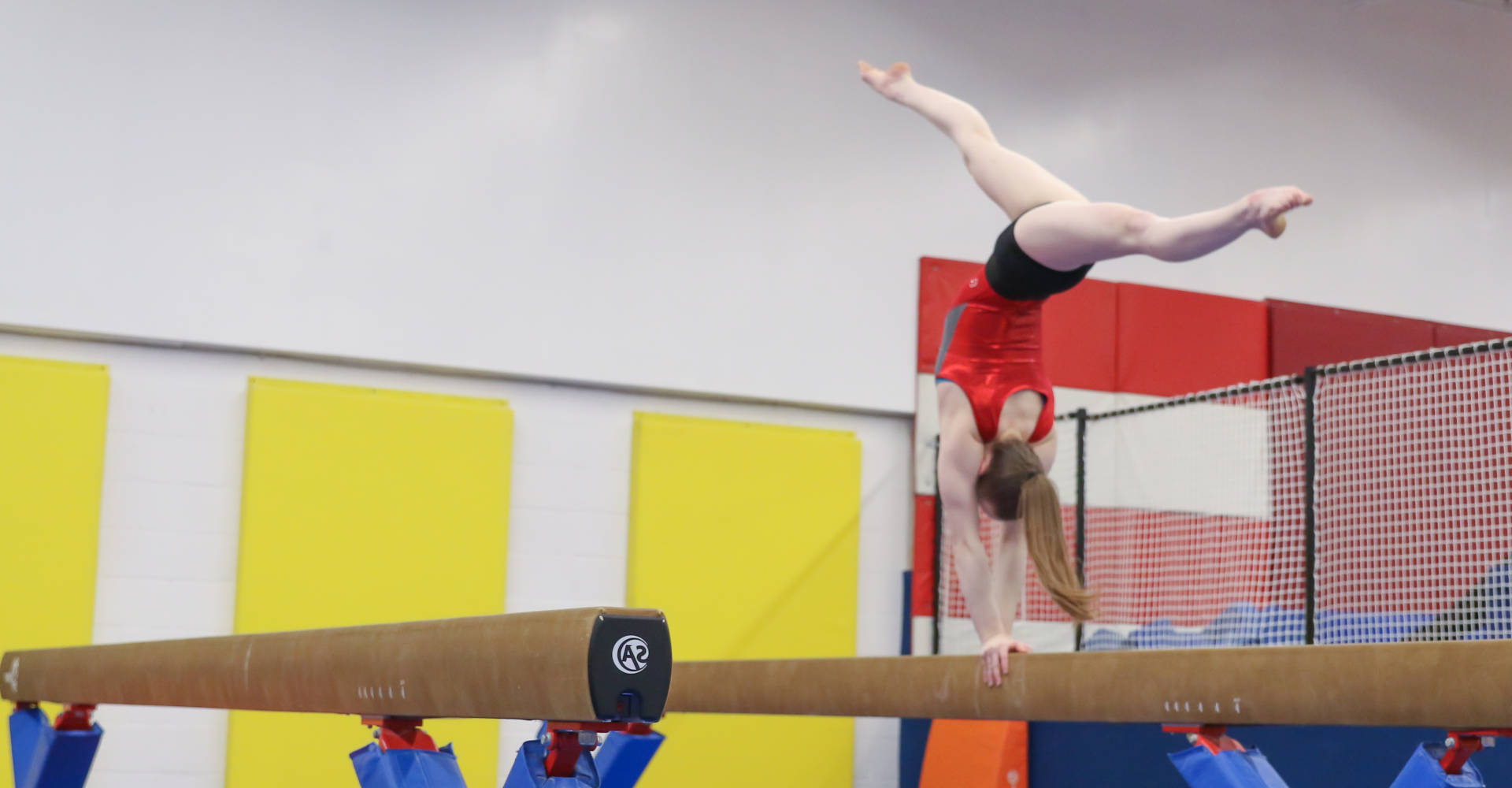 Gymworld Gems at Gymworld in London Ontario - Gymnast performing a back walkover on a balance beam at Gymworld gymnastics facility in Northwest London