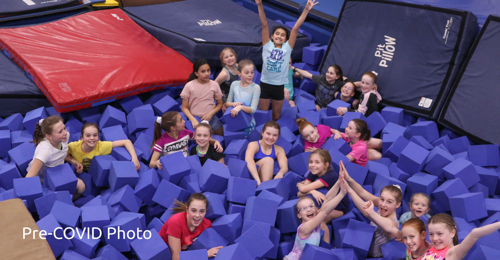 Gymnastics camp kids covered in large purple foam cubes at Gymworld Adventures in Gymnastics facility in London