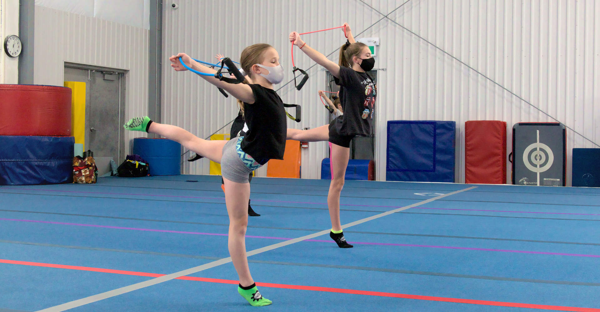 Young gymnasts warming up with back kicks on the spring floor at Gymworld Adventures in Gymnastics in Northwest London - a facility for recreational & competitive gymnastics in north London