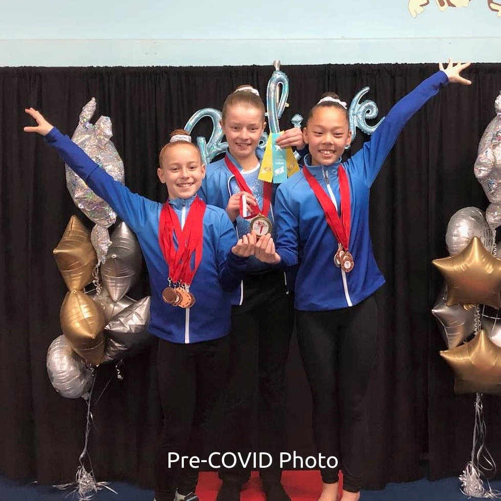 GW Elites gymnasts with their medals on a podium at a competion.